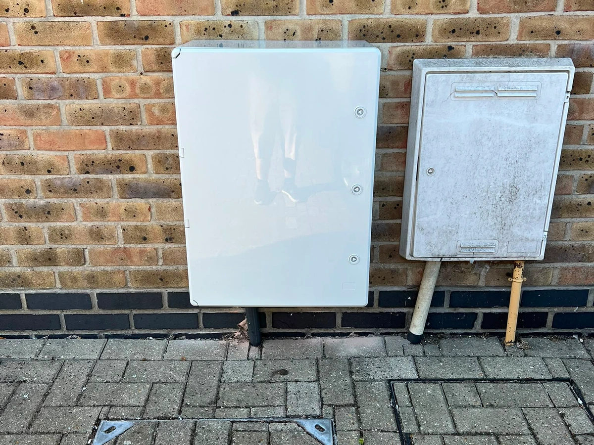 External electricity meter cabinet mounted on a brick wall