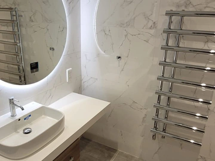 Backlit bathroom mirror and heated towel rail installed